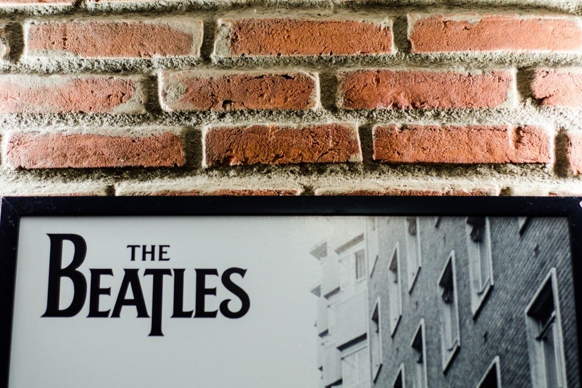 photo showing the top part of a Beatles poster against a brick wall