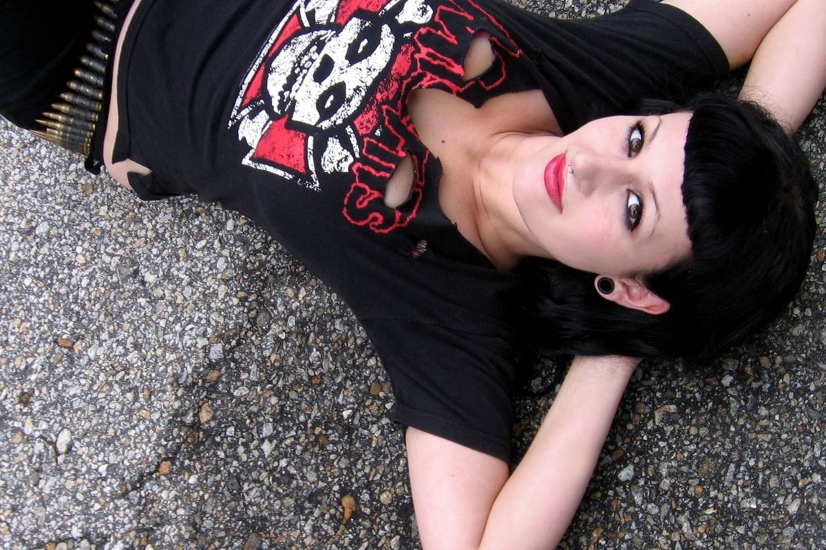 goth woman laying down on asphalt and photographed from above
