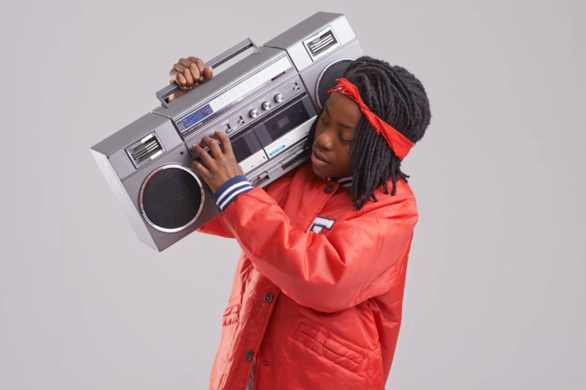 young African American man holding an 80's style boom box