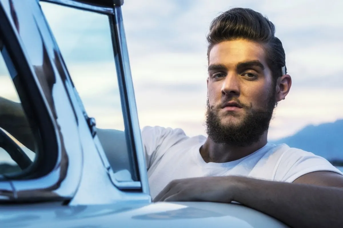 man wearing plain white shirt riding a top down car 