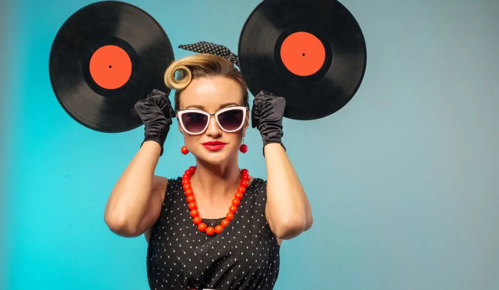 A photo of glamorous pin-up woman holding vinyl LP in hand
