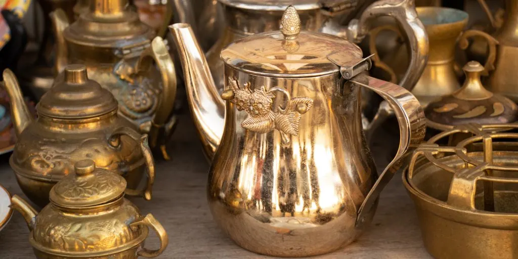 Copper antique jugs on the shelves, a collection of antique copper utensils