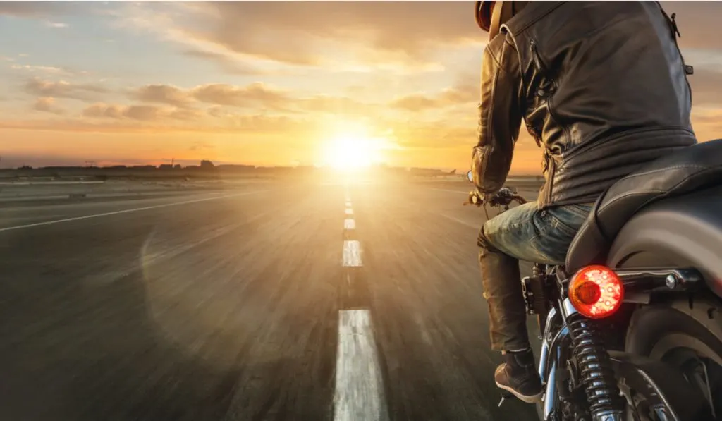 motorcycle rider alone in the street sunset 