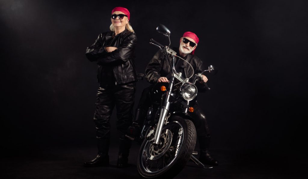 old couple rocker wearing leather jackets with a motorcycle