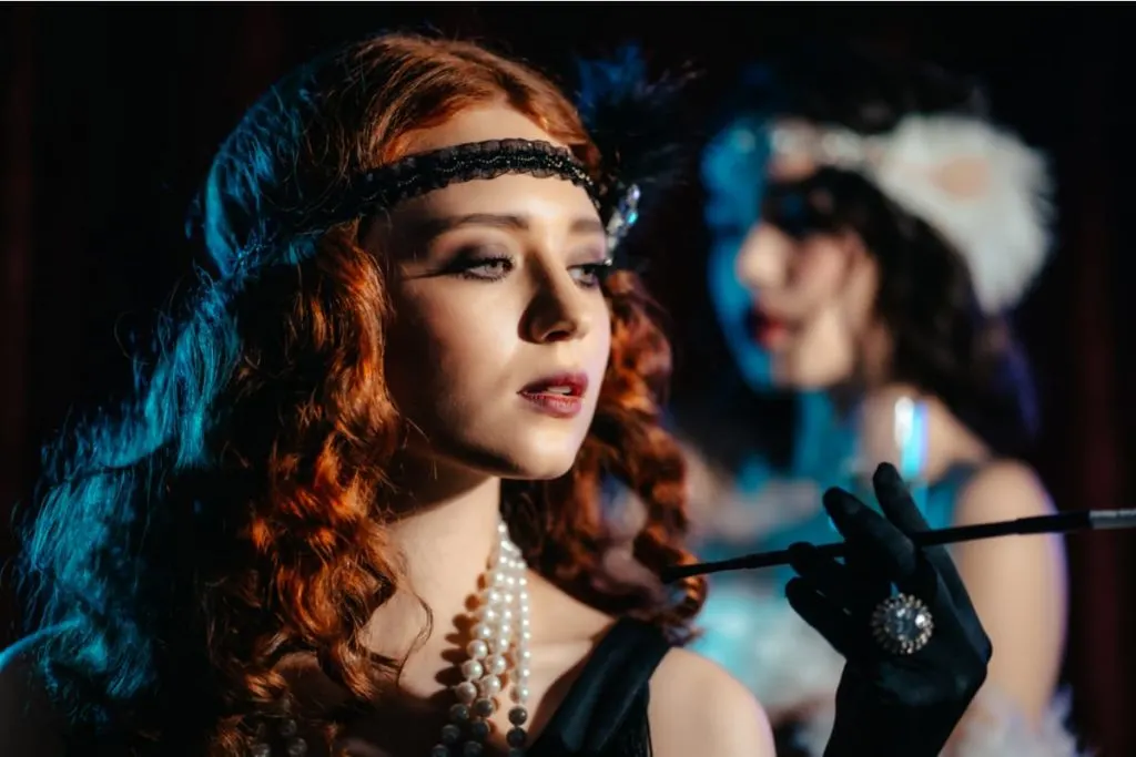 red haired flapper girl gangster girlfriend in black dress and white pearls