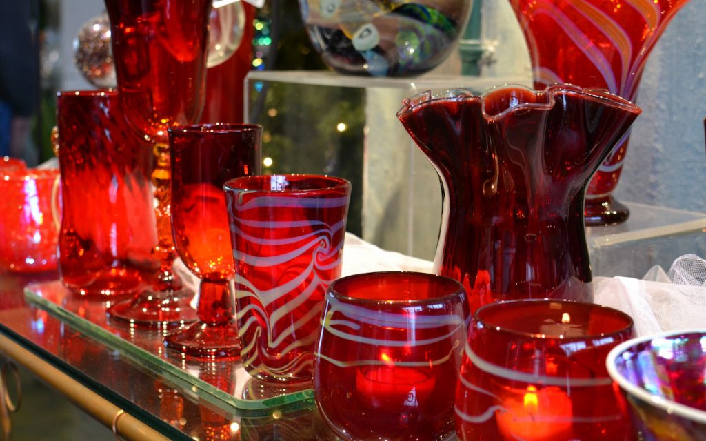 row of red glasses, vases and candle holders