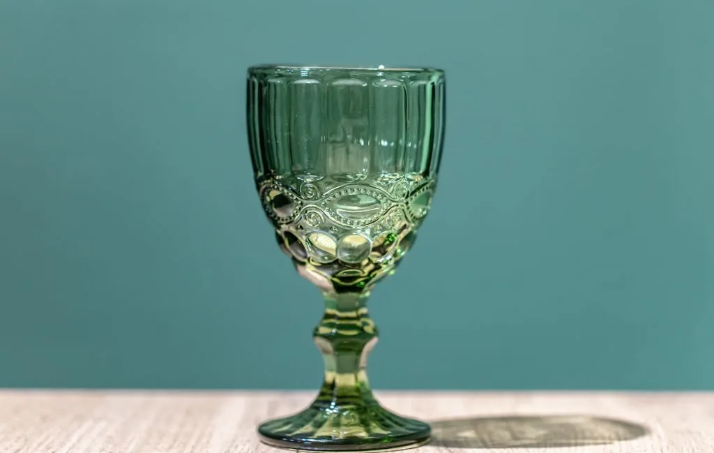 vintage uranium green glass on wooden table blue background