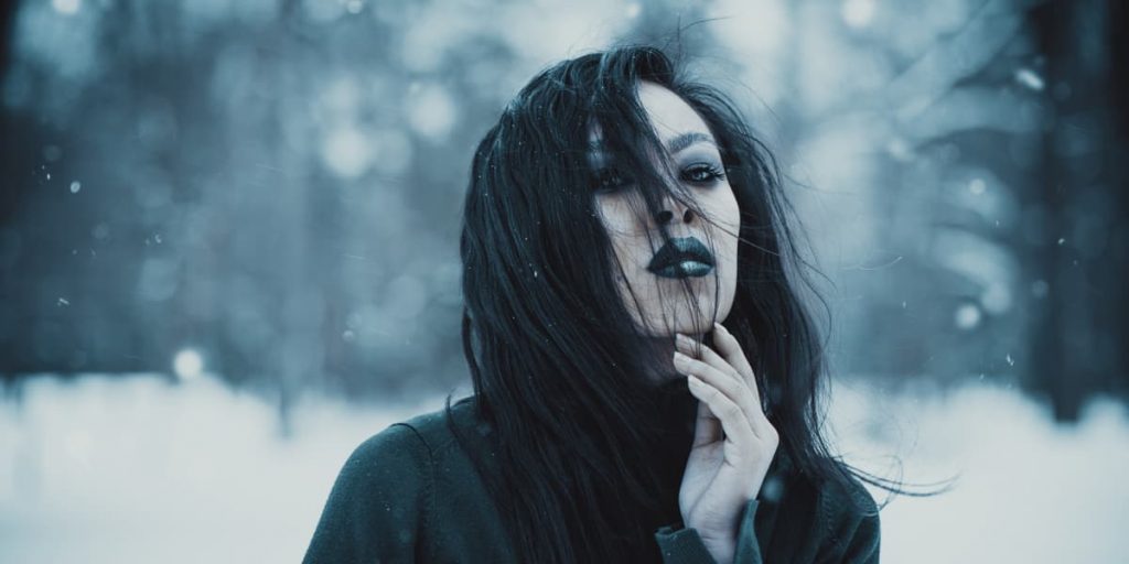 woman with goth makeup against a snow backdrop