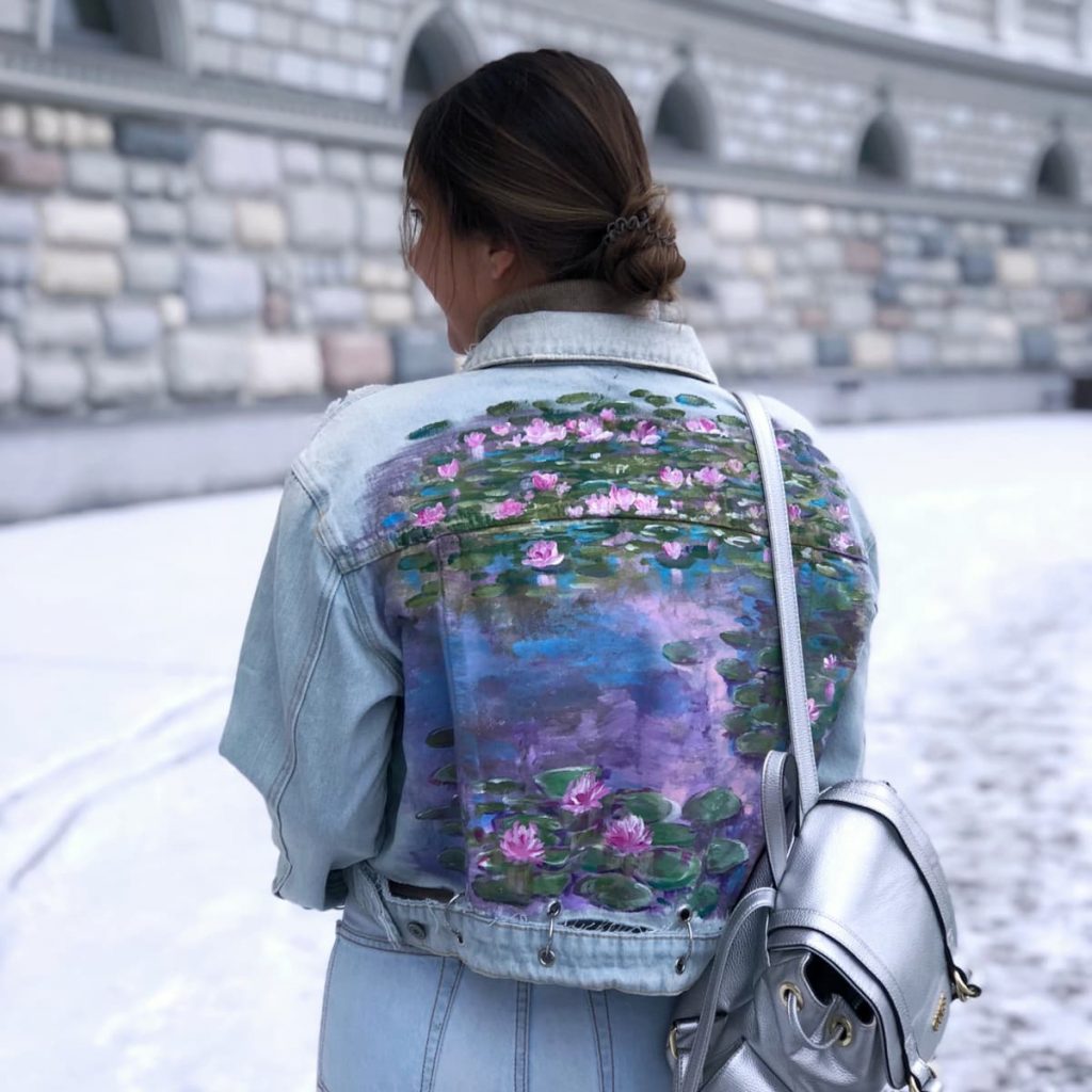woman with waterlilies painted on back of jean jacket